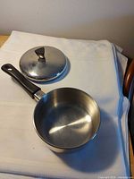 Saucepan with lid beside it, overall view