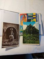 Album cover open showing several postcards including Central America promotional card, black-and-white statue card, ruins scene