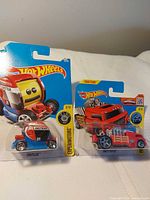 Front view of both packaged Hot Wheels cars