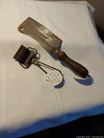 Cleaver and comb-head tool on white cloth