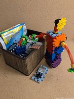Basket holding assorted Techno Gears parts, manuals visible, assembled sample structure beside basket