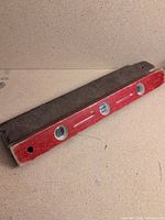 Full view of red wooden level and dark wood case