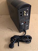 Rear view showing six outlets, RJ-45 ports, coax connectors, DB-9 serial, USB-B, LED, power cord