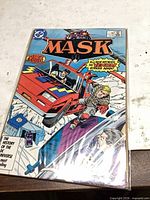 Front cover of bagged DC Comics M.A.S.K. issue #1 showing title, artwork, and price box.