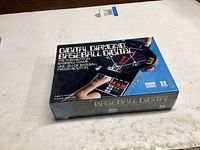 Front of sealed box showing product name, handheld game image, age rating and Parker Brothers logo