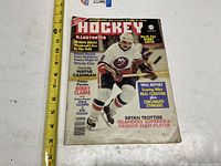 Front cover showing magazine title, date, cover athlete Bryan Trottier and ruler for scale