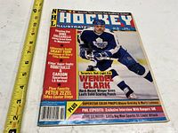 Front cover showing Wendel Clark and publication details with measuring tape for scale