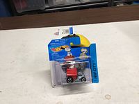 Front view of sealed Hot Wheels Peanuts Snoopy die-cast car on blister card