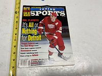 Front cover showing title, date, feature headline, and tape for scale