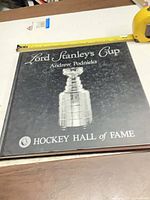 Front cover showing title, author, and image of Stanley Cup with tape measure indicating size