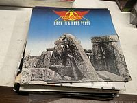 Front jacket of Aerosmith Rock in a Hard Place LP atop stack