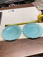 Two light blue glass plates with tape measure showing approximately 8 inches