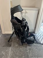 Side view of child carrier backpack showing metal kickstand extended and overall structure