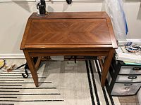 Desk closed showing wood finish and taper legs