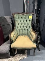 Front view showing tufted back, tan seat, carved wood frame