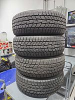 Stack of four matching Motomaster Winter Edge tires showing tread face
