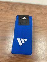 Front view of folded blue Adidas socks with retail hang tag