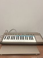 Front view of Bontempi 32-key keyboard with cover in foreground