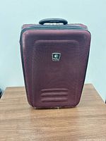Front view of burgundy softside carry-on suitcase