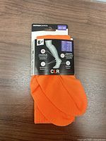 Front view of packaged orange Decathlon Kipsta CLR compression socks showing size 43/44 label