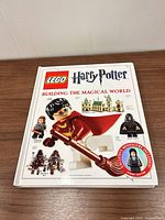 Front cover of hardcover book with images of Harry Potter minifigure and sticker indicating exclusive minifigure