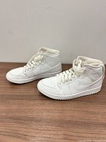 Both sneakers side view on tabletop showing uppers and laces