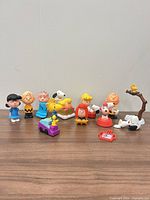 Full group of Peanuts figurines and accessories on tabletop