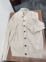 Cardigan front view laid flat showing overall style and buttons
