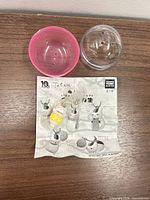 Full lot: capsule halves, insert sheet, bagged keychain charm
