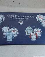 Full framed print showing title and several jerseys