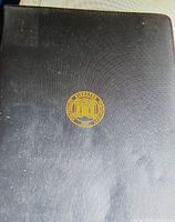 black hardcover padfolio closed with gold seal