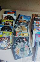 Multiple rows of jewel-case CDs with visible titles such as Fighter Squadron, Zap!, Winnie the Pooh Print Studio