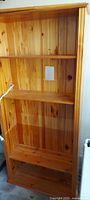 Front view of full pine bookcase showing shelves and back panel