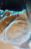 Two white washing machine hoses sealed in plastic bag