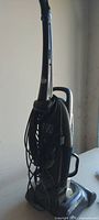 Side view of Dirt Devil upright vacuum showing coiled power cord and hose