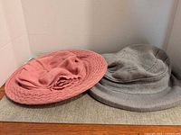 Dusty-rose wide-brim hat and grey heather cloche hat side by side