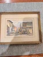 Monnegold village street scene print in gold-tone frame