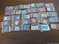 All 30 stamps in individual plastic sleeves displayed on table