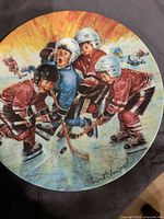 Front of plate showing hockey scene and artist signature