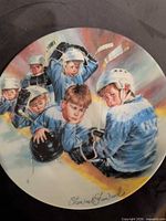 Front of porcelain plate showing boys playing hockey