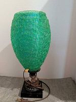 Full view of green textured table lamp with base and cord visible