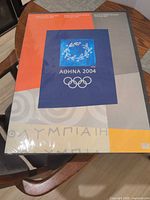 Full view of sealed Athens 2004 Olympic poster on table
