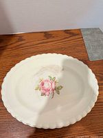 Top view of cream oval platter with rose motif and scalloped edge