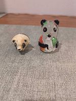 Both panda figurines side by side on fabric surface