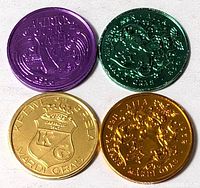Front faces of four anodized aluminum Mardi Gras doubloons in purple, green, gold and bronze