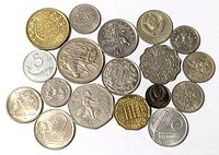 Full view of nineteen mixed world coins scattered on white background