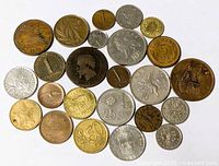 Overall spread of 25 coins showing variety of sizes, metals, designs