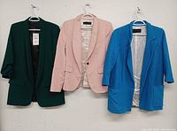 Front view of all three blazers: green, pink, blue