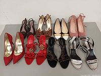 Eight pairs of assorted women’s heels laid out front view