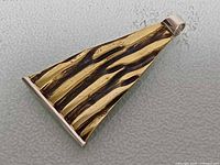 Front view showing brass textured design on silver pendant